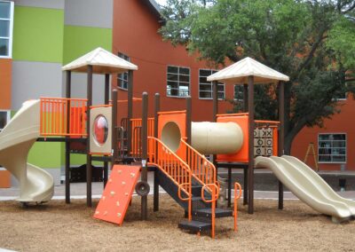 Orange and tan commercial playground with twin towers and slides