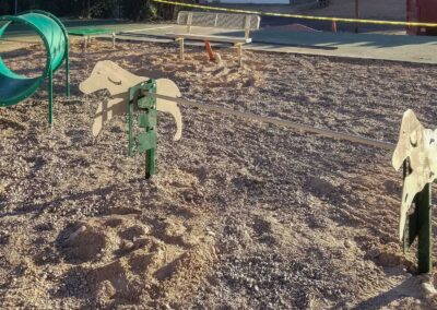 Tan spring riders and low play equipment on wood mulch surfacing