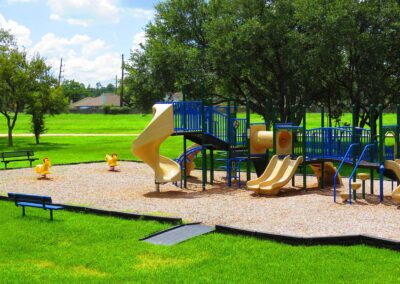 Blue and tan commercial playground with slides in a city park