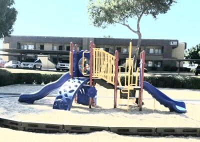 Blue and tan commercial playground with double slides at an apartment complex