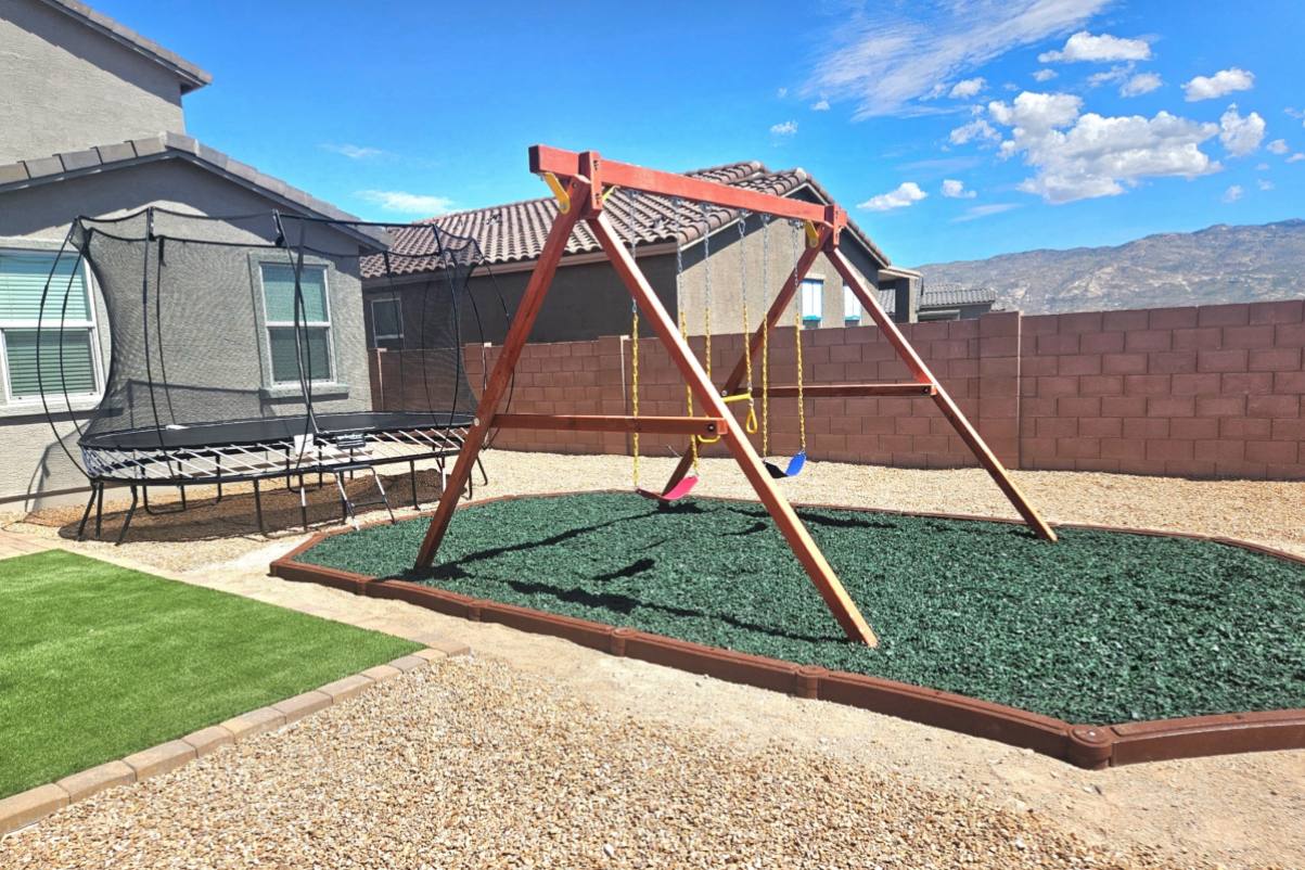 Backyard cedar playset with slide and swings in a Tucson desert yard